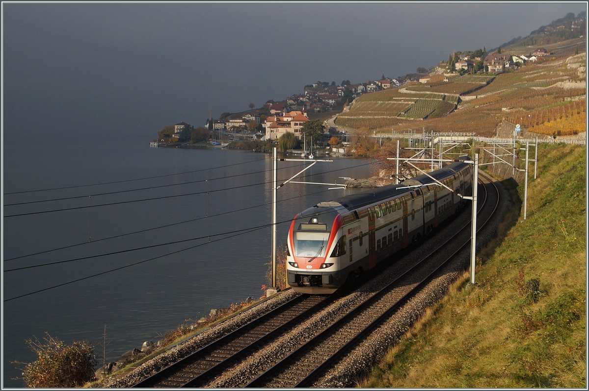 Bei Nebenllagen im Mittelland ist oft das östliche Genferseebecken Nebelfrei, die Grenze liegt meist bei Cully. Heute jedoch lag die Nebelgrenze weit östlicher, bei Rivaz. Dies bescherte dem sonnenbeschienenen SBB RABe 511 114 als RE 2716 von Vevey nach Genève zwischen St Saphorin und Rivaz unterwegs, eine ungewohnte Hintergrundskulisse. 22. Nov. 2014 