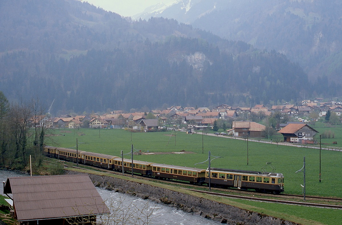 Bei Wilderswil ist ein ABeh 4/4 der BOB mit einem Zug nach Interlaken unterwegs, im Vordergrund das Gleis der Schynige Platte-Bahn (Mai 1981)