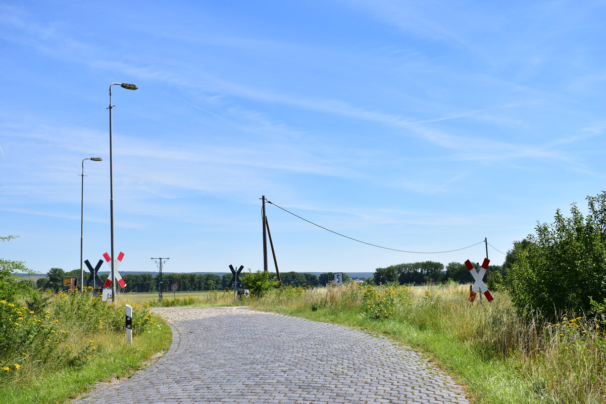 Blick auf den Bahnübergang Kupferhüttenweg in Donndorf. Einst war der Bahnhof und die Bahnübergänge mechanisch. Heute ist Donndorf nur noch Haltepunkt und sämtliche BÜ lediglich mit Andreaskreuzen gesichert. Seit Ende 2006 ist hier der Nahverkehr eingestellt. Es finden gelegendlich Sonderfahrten von Wangen aus statt. Der Abschnitt Nebra - Artern gehört heute der Deutschen Regionaleisenbahn DRE. (Foto: Dennis Fiedler)