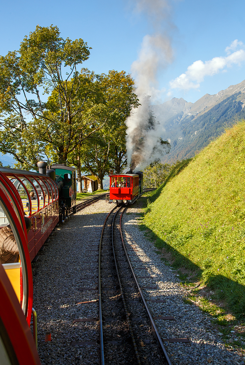 
Brienz-Rothorn-Bahn (BRB), Zugbegegnung an der Kreuzungsstelle Geldried (1.024 m ü.NN) am 25.09.2016: Während wir uns mit der ölgefeuerten BRB 15 - Stadt Kanaya (Japan), Baujahr 1996 eine Lok  der 3. Generation,  auf Talfahrt nach Brienz befinden, wartet rechts bereits, die 1891 gebaute,  kohlegefeuerte B.R.B. 2 mit dem historischen Wagen B1 von 1892 auf freie Bergfahrt.