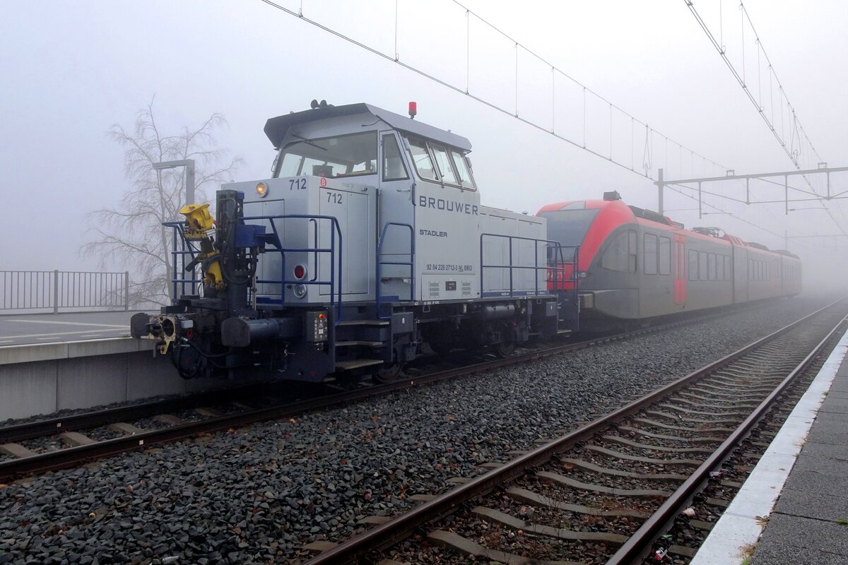 Brouwer technics 712 schleppt ein QBUZZ-GTW vons Bahnhof Blerick _wo in dichten Mist dieser Bild entstand- nach das Stadlerwerk etwa 250 meter weiter. In Blerick wurden alle Stadler-Triebzüge von die Niederlände unterhalten. Und dass heisst: Arriva Noord (die nördliche Provinzen Friesland und Groningen), Arriva Limburg (NLs südlichsten Provinz), R-NET/Q-BUZZ (meistens aktiv in die stark urbanisierte 'Randstad' Revier ins Westens Niederlands) und BRENG/Arriva Oost (aktiv in Gelderland) bringen alle deren Triebzüge von Typen GTW, Flirt-1 und Flirt-3 nach Blerick.