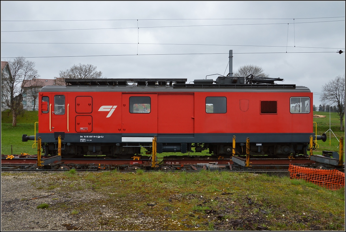 Chemins de fer de Jura (CJ). Ungewähnlicher Rollschemelverkehr mit aufgebocktem Triebwagen De 4/4 in Saignelégier. April 2016.

Dieser Gepäcktriebwagen hat eine ungewöhnliche Geschichte über mittlerweile 106 Jahre. Mangels Mitteln für eine Neubeschaffung wurden immer wieder Teile erneuert, so dass nach zahlreichen Umbauten heute wohl ein Triebwagen neueren Datums zu sehen ist, der letzte große Umbau war 1980. 