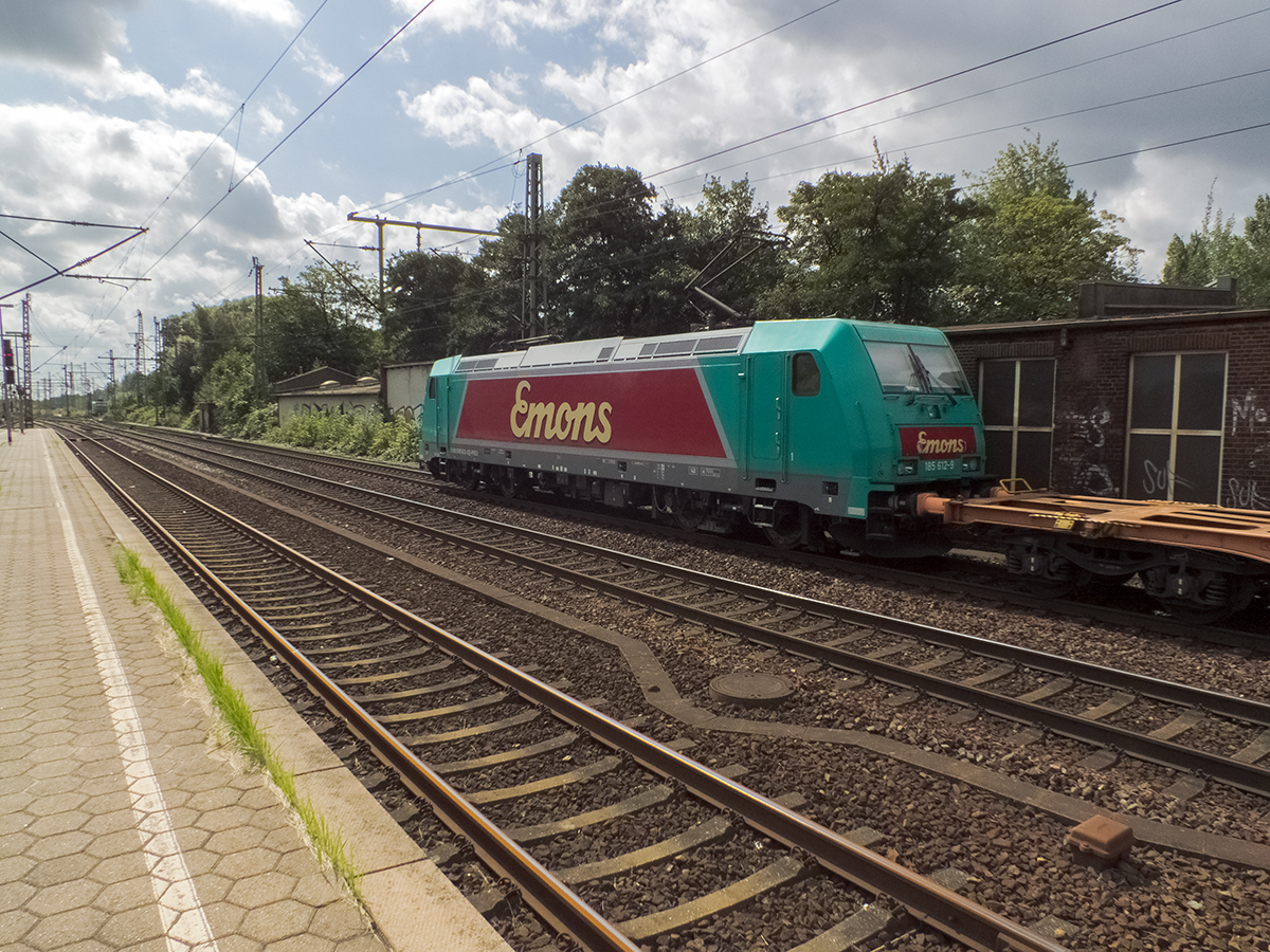 Da passt man einen Augenblick lang nicht auf und schon schleicht sich von hinten der erste Güterzug seit gefühlten Ewigkeiten an. Weil aber auf den Gütergleisen in Harburg Tempo 40 gilt und der erste Wagen leer war, konnte ich zumindest einen Nachschuss auf 185 612, die Werbung für die Spedition emons fährt, verwirklichen.