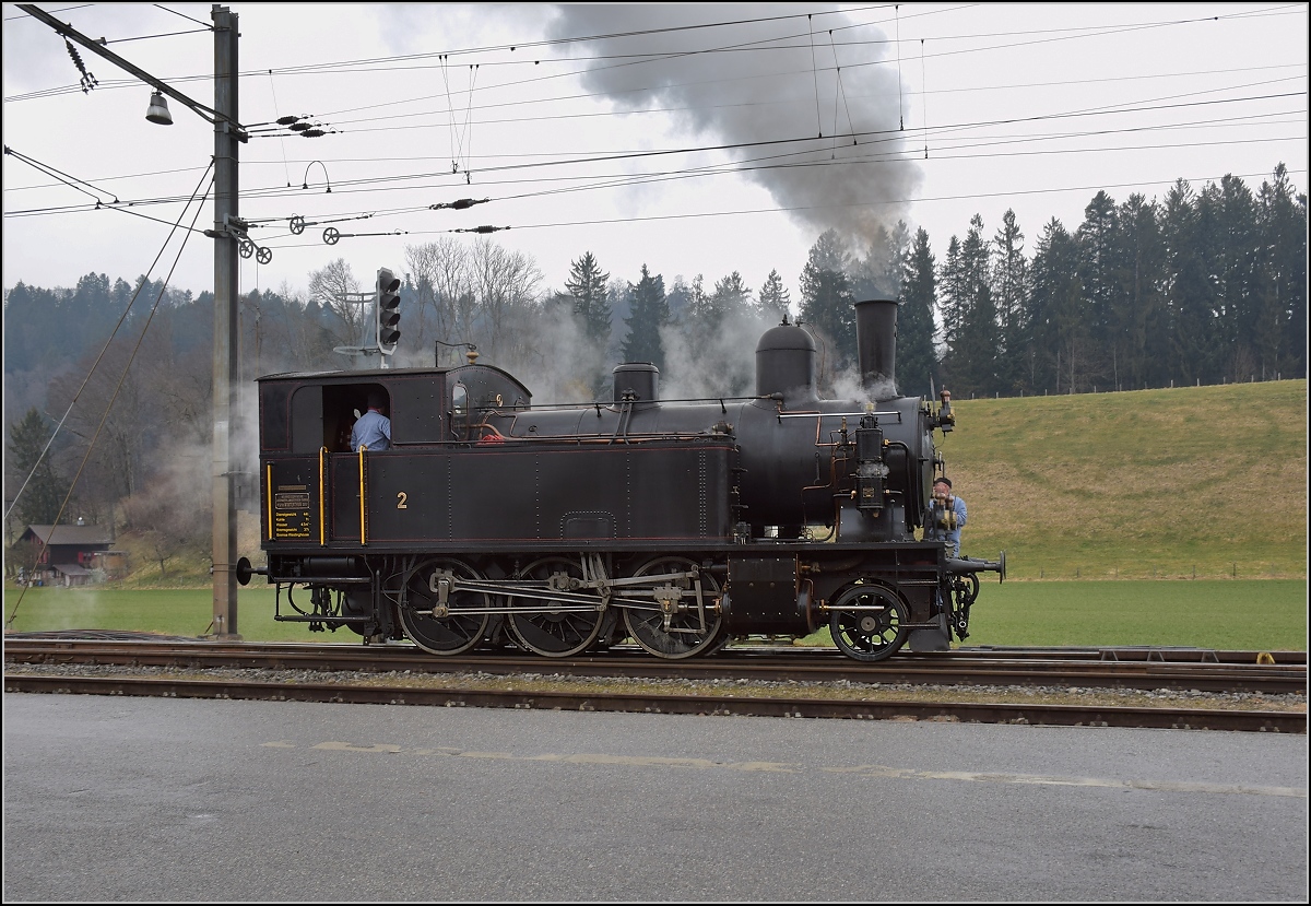 Dampflok Ed 3/4 Nr. 2 der Solothurn-Münster-Bahn auf dem Weg zur Ergänzung der Vorräte in Sumiswald-Grünen. Vorbei geht es auch an einem riesigen Smily im Gras. Februar 2018.