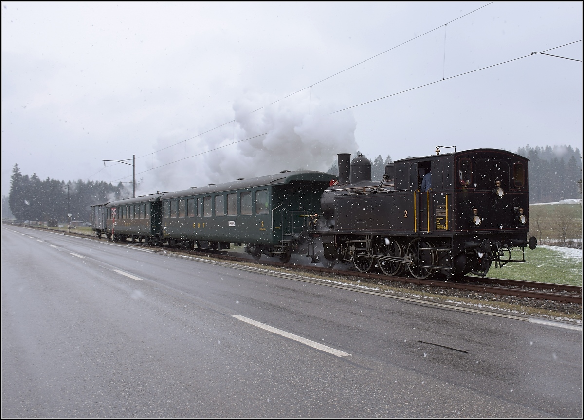 Dampflok Ed 3/4 Nr. 2 der Solothurn-Münster-Bahn bei Häusernmoos. Betreut wird die Lok durch den Verein historische Emmentalbahn. Mit im Gepäck hat sie zwei vierachsige Leichtstahlplattformwagen und einen K2. Februar 2018. 