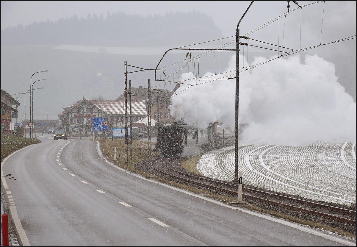 Dampflok Ed 3/4 Nr. 2 der Solothurn-Münster-Bahn bei Häusernmoos. Betreut wird die Lok durch den Verein historische Emmentalbahn. Mit im Gepäck hat sie zwei vierachsige Leichtstahlplattformwagen und einen K2. Februar 2018. 