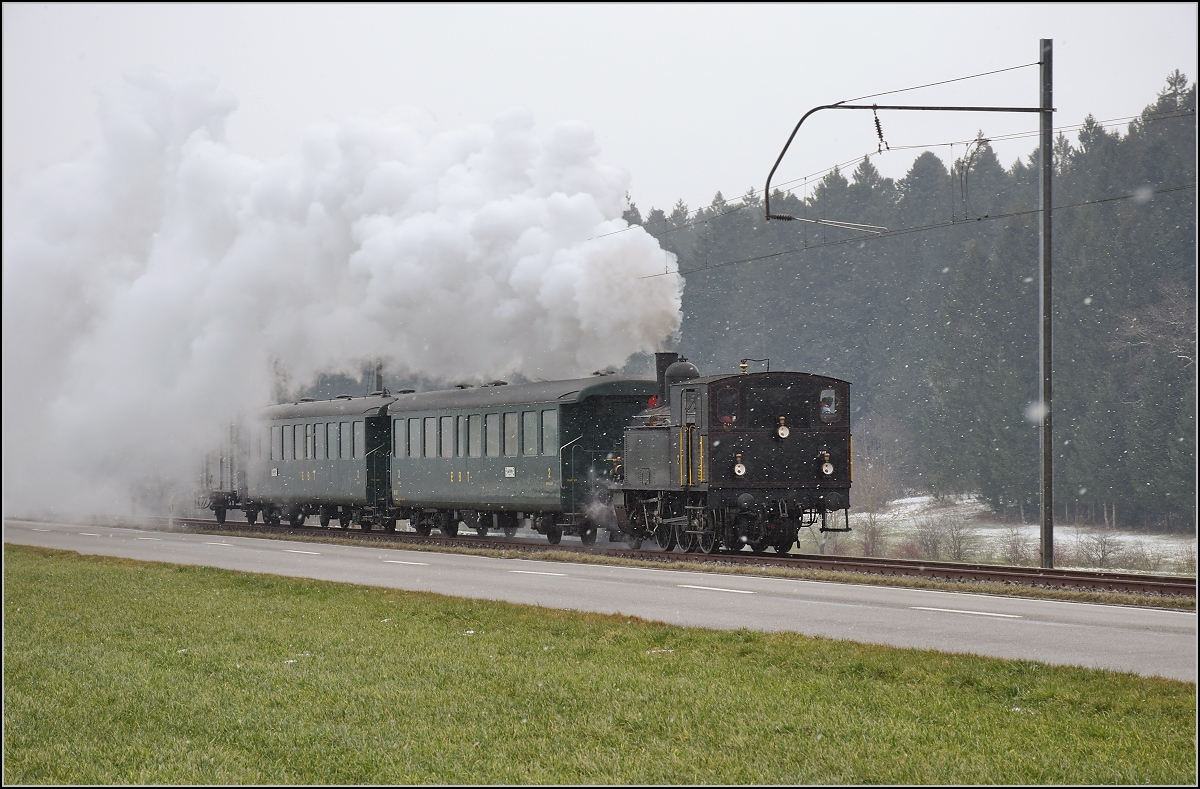 Dampflok Ed 3/4 Nr. 2 der Solothurn-Münster-Bahn bei Häusernmoos. Betreut wird die Lok durch den Verein historische Emmentalbahn. Mit im Gepäck hat sie zwei vierachsige Leichtstahlplattformwagen und einen K2. Februar 2018. 