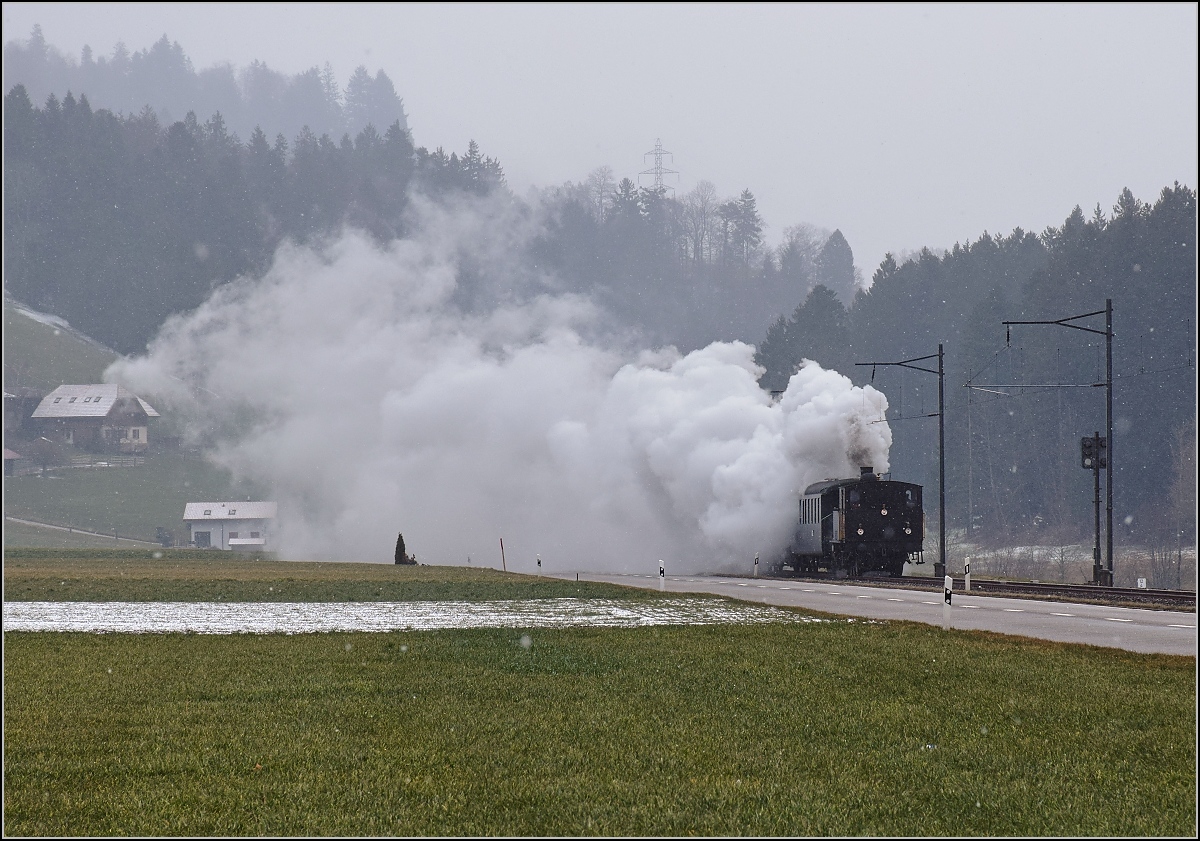 Dampflok Ed 3/4 Nr. 2 der Solothurn-Münster-Bahn bei Häusernmoos. Betreut wird die Lok durch den Verein historische Emmentalbahn. Mit im Gepäck hat sie zwei vierachsige Leichtstahlplattformwagen und einen K2. Februar 2018. 