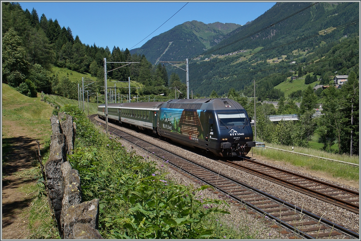 Das  behäbige  Bauernhaus auf der Re 460 023-5 will nicht so ganz in die alpensüdländliche Landschaft passen.
Links im Bild sieht man die typischen, auf weiten Strecken der Südrampe die Gotthardbahn säumenden Steinplatten, ganz im Hintergrund ist die steilste Standseilbahn von Piotta ach Piora (Ritom) zu erahnen. 24. Juni 2015