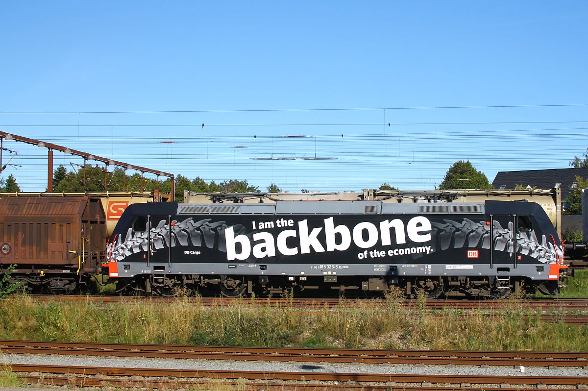 DB 185 325  Backbone  rollt mit ihrem Güterzug abgebügelt in den Bahnhof Pattburg/Padborg und passiert dabei eine Trennstelle in der Oberleitung 02.09.2022