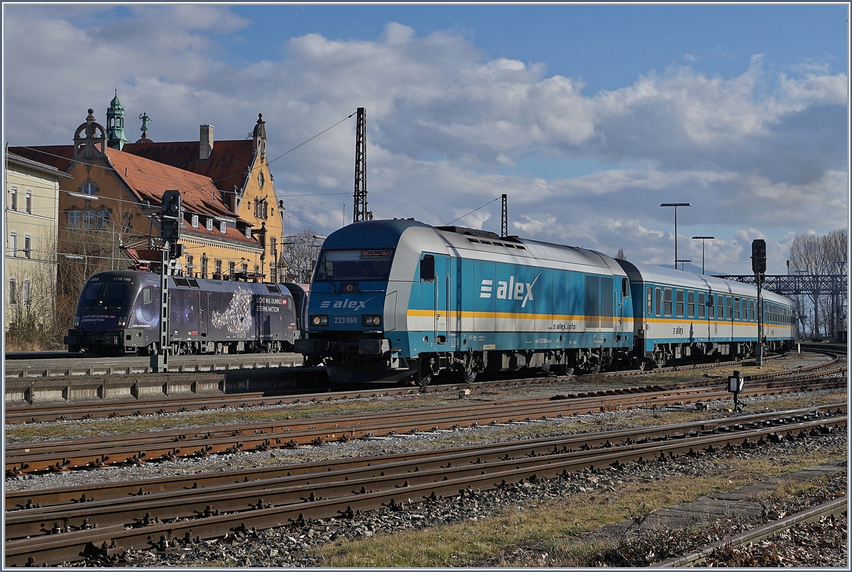 Dei Alex 223 069 verlässt mir ihrem  Alex  nach München Lindau Hbf. Im Hintergrund wartet die ÖBB 1116 158  Licht ins Dunkle  mit em IC Bodensee auf die Abfahrt Richtung Innsbruck.
16. März 2018