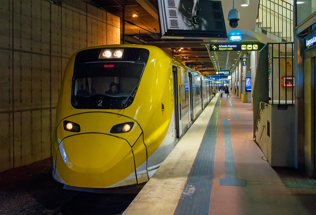 Der Arlanda Express Triebzug 2, ein Alstom Coradia X3, steht am 21.03.2019 auf Gleis 1 in Stockholm Central zur Abfahrt nach dem Flughafen Stockholm/Arlanda bereit.

Der vierteilige, normalspurige elektrische Triebwagenzug vom Typ X3 wird von der schwedischen Gesellschaft Arlanda Express fr den direkten Verkehr zwischen Stockholm C und Flughafen Stockholm/Arlanda verwendet.

Von Alstom wurden sieben dieser klimatisierten Zge in Birmingham gebaut und 1998/99 geliefert. Der X3 gehrt zur Obergruppe der Coradia-Triebwagen und kann Geschwindigkeiten bis 205 km/h erreichen. Die Zge sind wei und gelb lackiert. Die Triebwagen nutzen das gleiche Stromsystem, wie es im gesamten schwedischen Eisenbahnnetz vorhanden ist.

TECHNISCHE DATEN:
Spurweite: 1435 mm (Normalspur)
Achsformel: Bo'Bo'+2'2'+'2'2+Bo'Bo'
Lnge ber Kupplung: 93.084 mm
Dienstgewicht: 187 t
Hchstgeschwindigkeit: 200 km/h
Leistung: 2.240 kW
Stromsystem: 15 kV 16 2/3 Hz ~
Sitzpltze: 228

Arlanda Express ist eine schwedische Bahnverbindung, die mit dem 200 km/h schnellen Elektrotriebzug X3 seit 1999 den Stockholmer Hauptbahnhof mit dem Flughafen Stockholm/Arlanda verbindet. Die Zge bewltigen die Strecke in 20 Minuten. Am Flughafen bedienen sie die Stationen Arlanda Sdra und Arlanda Norra. Die Zge verkehren bis auf wenige Ausnahmen in den Tagesrandzeiten alle 15 Minuten, im Berufsverkehr etwa alle zehn Minuten.

In Arlanda und im Hauptbahnhof von Stockholm am Gleis 1 und 2 haben die Zge gesonderte Bahnsteige. Dort ist ein direkter stufenloser bergang vom Zug zum Bahnsteig mglich. Jeder Wagen verfgt ber zwei Tren und an jeder Tr sind Gepckablagen vorhanden. Der gesamte Zug besitzt 190 Sitzpltze. In einem der Wagen sind gesonderte Pltze fr Rollstuhlfahrer sowie ein WC vorhanden.

