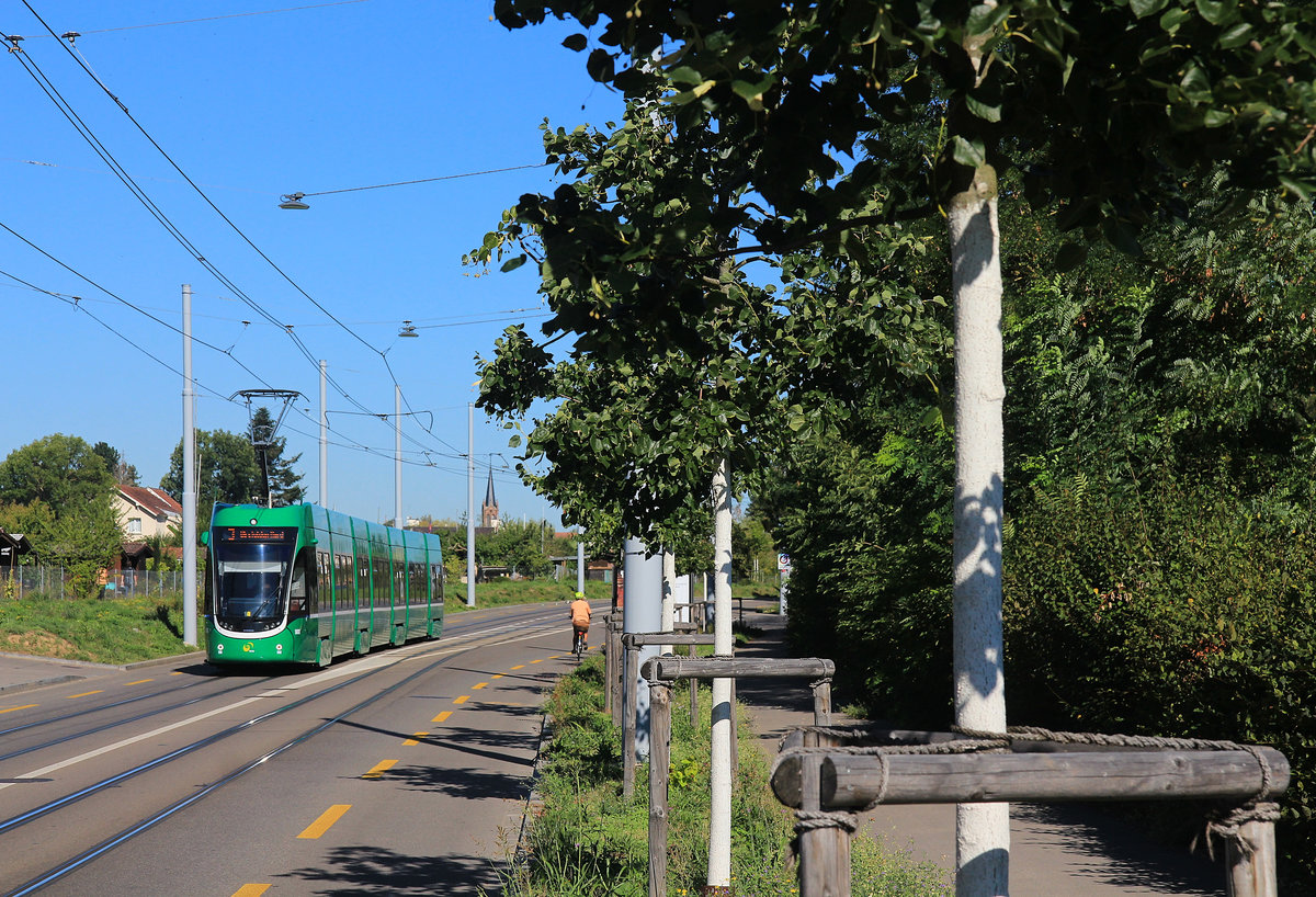 Der Basler Flexity Wagen 5033 kommt vom Zollamt Schweiz/Frankreich am Burgfelderhof auf der Neubaustrecke an die Landesgrenze her. Im Hintergrund die Eglise Saint Charles im französischen Bourgfelden. 20.August 2020 