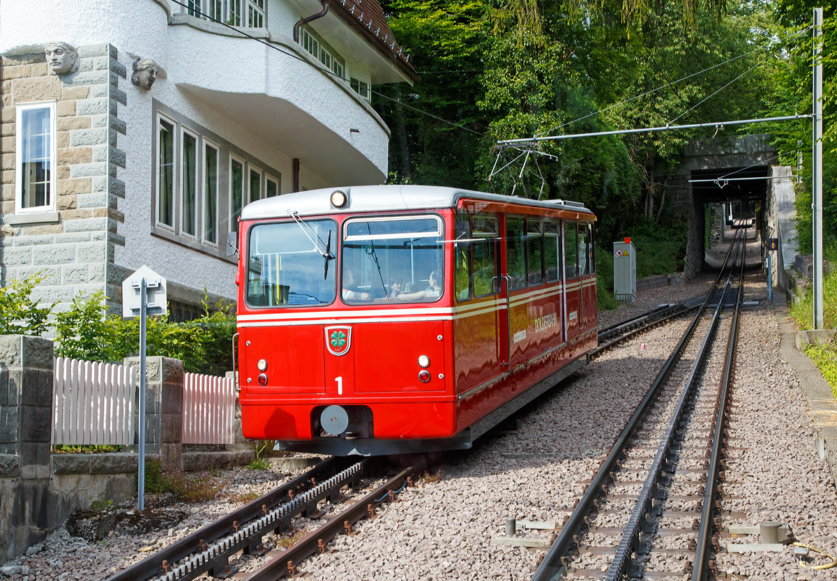 Der elektrischer Zahnradtriebwagen Bhe  1/2 Nr. 1 der Dolderbahn muss am 06.06.2015 in der Ausweichstelle auf den Gegentriebwagen Nr. 2 warten.

Die beiden Elektrischer Zahnradtriebwagen Bhe  1/2 der Dolderbahn
Im Jahr 1972 stellte die Dolderbahn- Betriebs AG den Seilbahnbetrieb ein, verlängerte die Strecke um rund 500 m auf 1,3 km und verlegte eine Lamellenzahnstange (System von Roll) in das erneuerte Gleis. Für den Zahnradbetrieb lieferte die SLM 1973 zwei zweiachsige Zahnradtriebwagen. Jeder dieser Zahnradtriebwagen hat talseitig eine Triebachse und bergseitig eine Bremsachse. Ein im Untergestell in Längsrichtung angeordneter Fahrmotor treibt über eine Kardanwelle und ein zweistufiges Getriebe das Triebzahnrad an. Die Verbundbauweise des Wagenkastens mit dem Untergestell ergibt eine selbsttragende, leichte und solide Konstruktion.  Volle Betriebssicherheit wird durch eine elektrische Widerstandsbremse, eine Zahnradbremse sowie eine Klinkenbremse gewährleistet.

TECHNISCHE DATEN:
Hersteller: SLM (Schweizerische Lokomotiv- und Maschinenfabrik), Winterthur
Elektrischen Ausrüstung: BBC (Brown, Boveri & Cie. AG), Baden
Spurweite: 1.000 mm (Meterspur)
Zahnstangensystem: von Roll
Achsformel: 2z
Max. Steigung: 196 ‰
Länge über Puffer: 11.520 mm
Achsabstand: 5.400 mm
Laufraddurchmesser: 690 mm
Teilkreisdurchmesser Treib- und Bremszahnrad: 573 mm
Eigengewicht: 14,4 t
Max. Zuladung: 7,8 t
Leistung: 131,5 kW (dauernd) / 149,5 kW (einstündig)
Zugkraft: 22,9 kN (dauernd) / 27,2 kN (einstündig)
Höchstgeschwindigkeit: 25 km/h (Bergfahrt) / 16 km/h (Talfahrt)
Getriebeübersetzung: 1 : 10,45
Sitzplätze: 26
Stehplätze: 74
Fahrdrahtspannung: 600 V = (DC)

Die Dolderbahn ist eine Privatbahn in der Stadt Zürich. Die Zahnradbahn erschließt das Dolder-Gebiet im Quartier Hottingen ab der Haltestelle Römerhof am Römerhofplatz auf 444 Metern über Meer und endet in der Station Dolder auf dem Adlisberg auf 606 Metern über Meer. Die Bahn dient nebst der Verbindung mit dem Wohnquartier auch als Zubringer für zwei Hotels, dem Wellenbad Dolder, der offenen Eisbahn Dolder und dem als Naherholungsgebiet dienenden Adlisberg.

Die Betreibergesellschaft wurde 1893 gegründet. 1895 wurde der Betrieb als Standseilbahn aufgenommen. Sie führte auf einer Strecke von rund 800 Metern vom Römerhofplatz zum Hotel Waldhaus Dolder auf 548 Metern über Meer.

Zur Verbindung mit dem Grand Hotel Dolder wurde am 5. Juli 1899 ein meterspuriges Tram in Betrieb genommen. Es wurde mit einem einzigen Wagen gleicher Bauart wie die StStZ-Wagen 57–84 betrieben. Die Strecke hatte keine direkte Verbindung zum Zürcher Tramnetz, jedoch sorgte die StStZ für den Unterhalt des Motorwagens und stellte während einer längeren Revision einen Ersatzwagen. Am 31. Dezember 1930 wurde das Dolder-Tram eingestellt und ein Bus übernahm die Verbindung zwischen Waldhaus und Grand Hotel.

Zwischen 1972 und 1973 wurde die Standseilbahn durch eine Zahnradbahn ersetzt und die Strecke bis zum Grand-Hotel Dolder verlängert. Weil dazu eine Kurve nötig war, wurde aus der Seil- eine Zahnradbahn. Seither misst sie 1.328 Meter und überwindet dabei eine Höhendifferenz von 162 Metern mit einer Neigung von maximal 19,6 Prozent. Weitere Vorteile gegenüber einer Standseilbahn sind, die Bahntrasse kann besser dem Gelände angepasst werden, die Ausweichstelle muß nicht genau in der Mitte der Bahnstrecke liegen. Zudem ist ein Einwagenbetrieb oder ein späterer Ausbau für automatischen Betrieb möglich.
