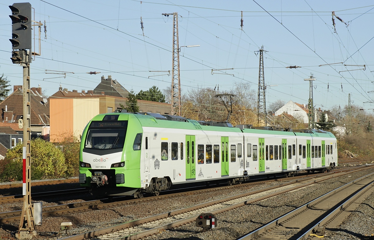 Der in den Farben des Verkehrsverbundes Rhein-Ruhr lackierte Abellio-Flirt 3XL 3427 003 (Baureihe 3427) ist am 18.11.2020 auf der S 2 Dortmund - Essen eingesetzt, hier bei der Einfahrt in Gelsenkirchen Hbf.