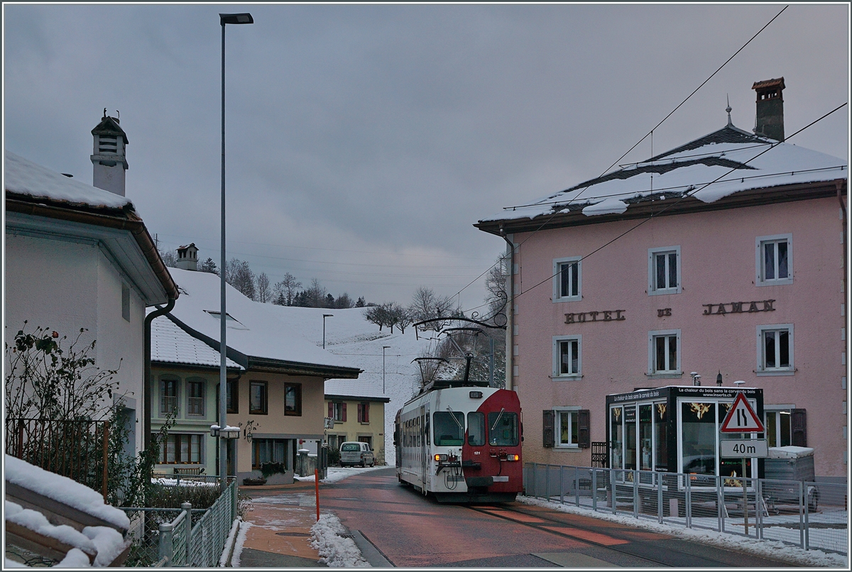 Der TPF Be 4/4 121 mit dem B 207 (ex MOB), B209 (ex MOB) und dem ABt 221 ist kurz nach der Abfahrt in Montbovon  auf der Strasse  unterwegs. Ziel des Zuges: Bulle. 

3. Dez. 2020