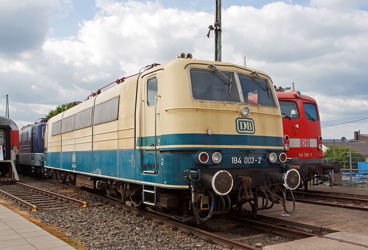 Die 184 003-2, ex DB E 410 003, am 14.06.2014 ausgestellt im DB Museum Koblenz-Lützel. 

Die Mehrsystem-Elektrolokomotive wurde 1966 bei Krupp in Essen unter der Fabriknummer  4837 gebaut, der elektrische Teil ist von AEG. Bei der Deutschen Bundesbahn (DB) wurde sie als E 410 003 in Dienst gestellt.  Mit der Einführung der EDV-Nummer wurde sie zum 01.01.1968 umgezeichnet in DB 184 003-2.  Am 01.04.2002 wurde sie bei der DB AG ausgemustert.

Um einen zeit- und arbeitsintensiven Lokwechsel in den Grenzbahnhöfen zu vermeiden, vergab die Deutsche Bundesbahn 1964 einen Entwicklungsauftrag an AEG, BBC sowie Krupp. Aufgabe war die Entwicklung einer Lokomotive, die den Fahrstrom aus unterschiedlichen Netzsystemen beziehen konnte. Da in den 1960er Jahren der grenzüberschreitende Verkehr nach Frankreich, Belgien und Luxenburg zunahm, entschied man sich bei der Entwicklung für eine vier Systemlokomotive.

Die Baureihe E 410 verfügte über die Ausrüstung zum Betrieb unter mehreren verschiedenen Oberleitungsspannungen. Sie konnte Einsätze unter dem deutschen (15 kV 16,7 Hz) und dem französischen (25 kV 50 Hz) Wechselstromsystem sowie dem belgischen und französischen Gleichstromnetz (3 kV bzw. 1,5 kV) fahren und brachten ihr schnell den Beinamen „Europa-Lok“ ein. Als charakteristisches Merkmal hatte die Baureihe E 410 ursprünglich vier Stromabnehmer. 
Die ersten fahrplanmäßigen Einsätze erfolgten vor Schnellzügen zwischen Köln und dem belgischen Lüttich ab Sommer 1969. Beheimatet waren die 184 im Bw Köln-Deutzerfeld . Die Thyristor-Stromrichter, mit denen die Phasenanschnittssteuerung realisiert wurde, bereiteten im Netz der belgischen Staatseisenbahnen trotzdem Probleme.  Außerdem kam es zu häufigen Lokausfällen aufgrund plötzlich auftretender starker Spannungsschwankungen im belgischen Gleichstromnetz. Der Einsatz im belgischen Netz wurde daher zum 26. September 1971 beendet. Daraufhin kamen die Loks aber im Nahverkehr rund um Köln zum Einsatz, teilweise mit D-Zügen sogar bis nach Rheine. Weil die Lokomotiven so aber nicht wirtschaftlich eingesetzt waren, zog die Bundesbahn 1979 die Maschinen nach Saarbrücken ab und legte die Systeme für Gleichstrombetrieb, einschließlich der betreffenden Stromabnehmer, still.

Aus dieser Baureihe wurden später auch die vier Zweisystemlokomotiven der Baureihe E 310 (ab 1968: Baureihe 181.0) abgeleitet.

Aus der Achsfolge Bo'Bo' geht hervor, dass die Lokomotiven zwei Drehgestelle mit insgesamt vier Fahrmotoren und damit vier angetriebenen Achsen besitzt. Die Kraftübertragung erfolgt mittels Gummiring-Kardanantrieb. Erstmals wurden Drehgestelle mit Lemniskatenanlenkung für besseren Kurvenlauf angewendet. Da die Baureihe 184 sowohl mit Wechsel- als auch mit Gleichstrom betrieben werden sollte, wurden Mischstrommotoren benötigt. Die Lösung fand man in fremdbelüfteten sechspoligen Motoren für Spannungen bis 1500 V.

Nicht nur hier wurde damals hochmoderne Technik verwendet, aus den Mischstrommotoren ergaben sich auch besondere Anforderungen an die Steuer- und Stromrichterelektronik: so mussten Thyristoren eingebaut werden, die eine stufenlose Phasenanschnittsteuerung ermöglichten. Mechanische Schaltwerke entfielen somit und zusammen mit dem guten Kraftschluss zwischen Schiene und Rad wurde eine ebenso gute Regelbarkeit von Geschwindigkeit und Zugkraft erreicht.

Um einen Betrieb mit der geringeren Fahrdrahthöhe in Frankreich zu ermöglichen, wurde die Bauhöhe des Lokkastens dem französischen Umgrenzungsprofil angepasst. Die knapp 17 Meter langen, 84 Tonnen schweren Lokomotiven erreichen bei Dauerleistungen von 3000 Kilowatt Geschwindigkeiten von bis zu 150 km/h.

TECHNISCHE DATEN:
Spurweite: 1.435 mm
Achsfolge:  Bo'Bo'
Treibrad-Durchmesser: 1.250 mm
Eigengewicht: 84,0 t
Länge über Puffer:  16.950 mm
Höchstgeschwindigkeit: 150 km/h
Antrieb: Gummiring-Kardan
Leistung: 3.000 kW bei 91km/h
Zugkraft: 275 kN
Stromsysteme: 15 kV 16 2/3 Hz / 25 kV 50 Hz  (1,5 kV DC / 3 kV DC)
Kupplungsart: Schraubenkupplung