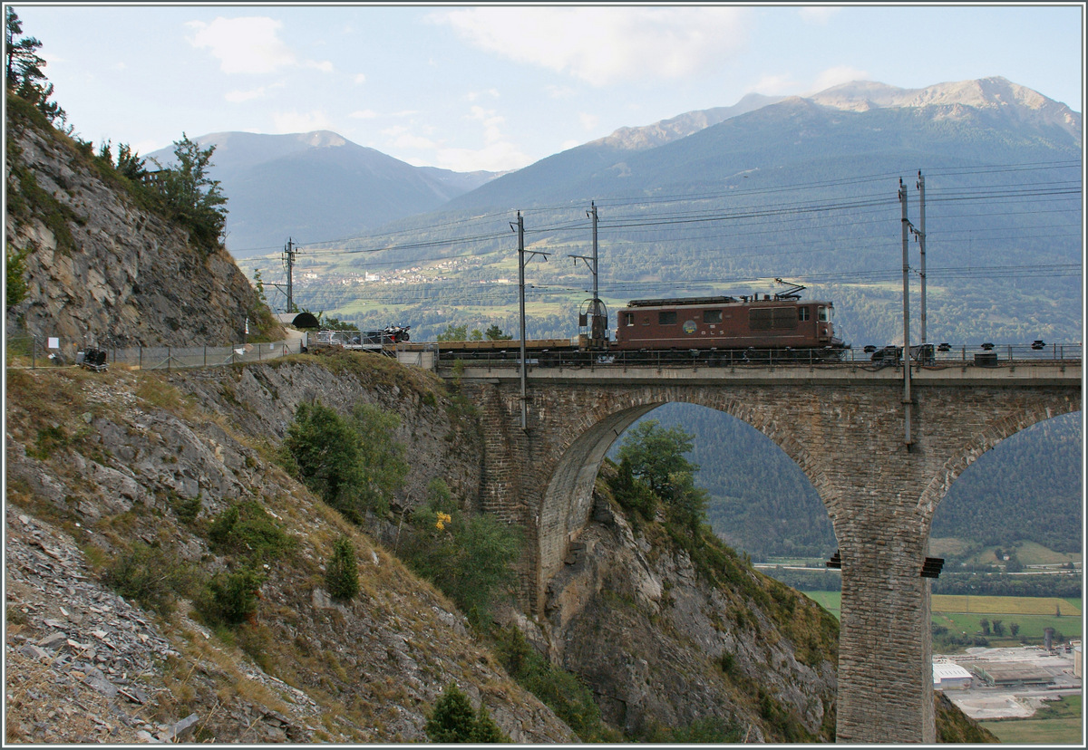 Die BLS Re 4/4 195 mit einem Autozug auf dem Weg von Kandersteg nach Iselle auf dem Luegelkinn Viadukt.
7. Sept. 2013