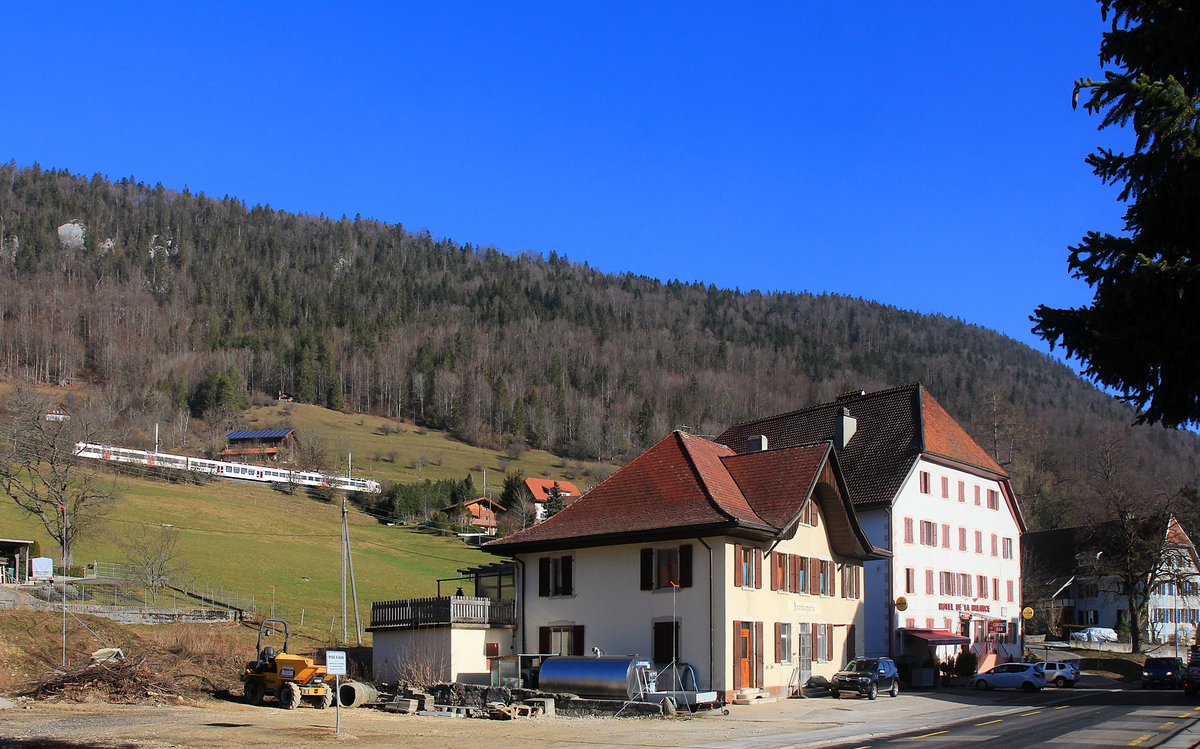 Die Eisenbahn im Vallon de St.Imier (Kanton Bern): Zwar erscheint der Domino-Zug in der grellen Sonne ziemlich farblos, doch vermitteln die alte (und wohl stillgelegte) Fromagerie und das riesige alte Hotel de la Balance eine sehr lokaltypische Jura-Atmosphäre. 25.Februar 2021