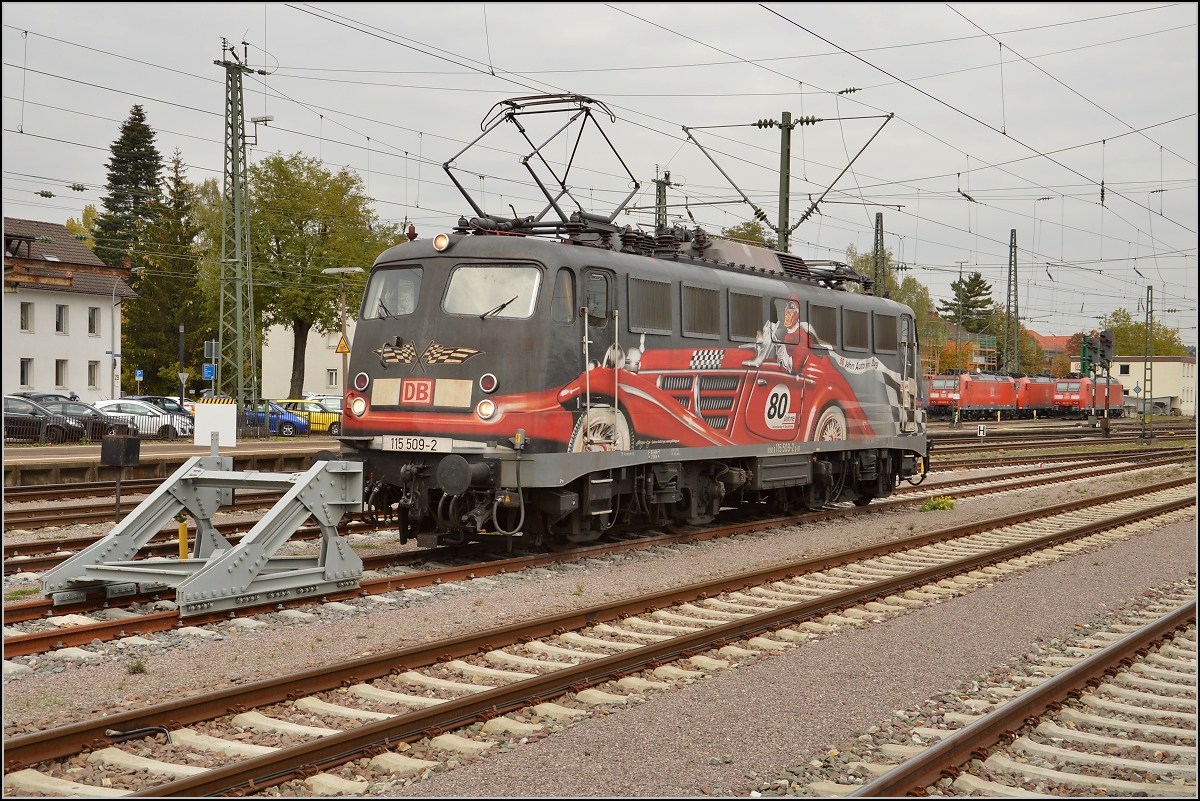 Die exotische 115 509-2 mit der Autozugwerbung in Diensten der Gäubahn-ICs wartet in Singen auf den nächsten Einsatz. Oktober 2015.