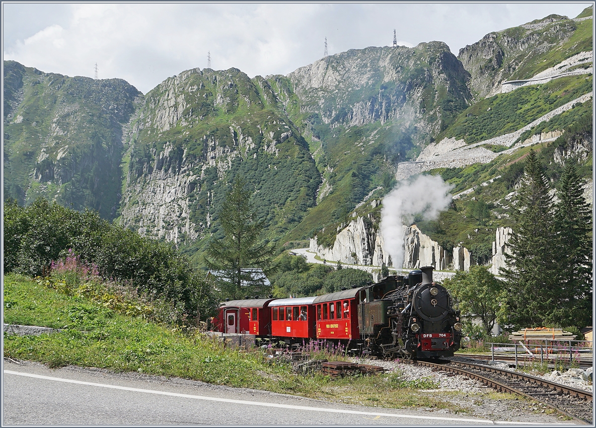 Die H 4/4 704 verlässt mit einen Reisezug zur Station Furka den Bahnhof von Gletsch.
Die Lok wurde 1923 von der SLM gebaut und nach Indochina geliefert, wo bis 1990 in Betieb bzw. Remisiert war. 1990 gelang die Rückführung in die Schweiz und danach dank 48 000 Stunden Freiwilligenarbeit die Aufarbeitung und Wiederinbetriebnahme der Lok bei der DFB. 

31. August 2019