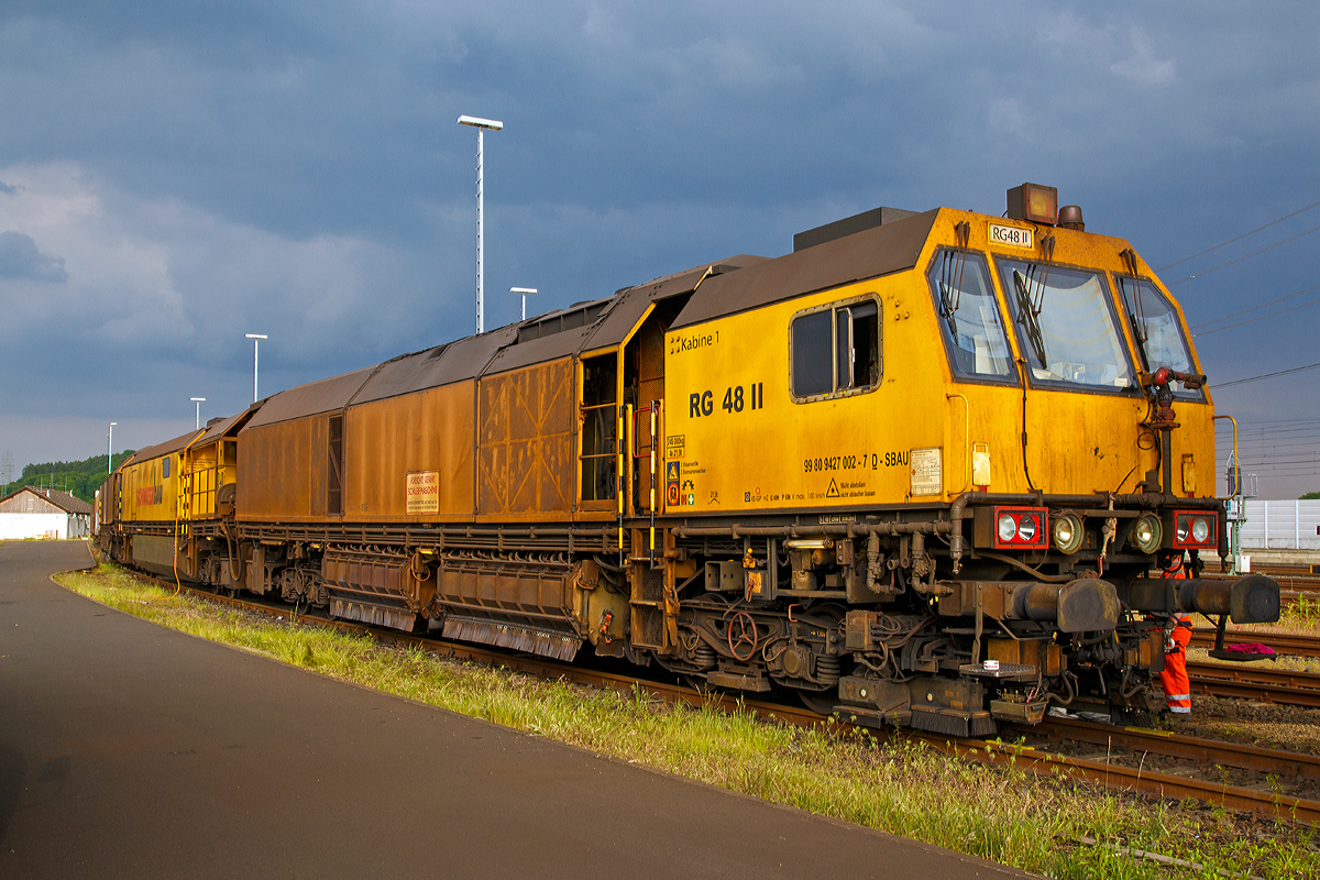 
Die LORAM Schienenschleifmaschine RG 48 II, Schweres Nebenfahrzeug Nr. 99 80 9427 002-7 D-SAUB, der Schweerbau abgestellt am 24.05.2015 beim ICE-Bahnhof Montabaur.

Die Schienenschleifmaschine RG 48 besteht aus drei Wagenteilen, zwei Schleifwagen (1+2) und eine Arbeitswagen dazwischen. Jeder Wagen hat zwei Drehgestelle mit zwei Achsen. Die Schleifwagen haben insgesamt 48 Schleifmodule (24 pro Wagen), die elektrisch verstellt werden können, der Anpressdruck geschieht hydraulisch. Die Schleifmotoren haben eine Leistung von jeweils 22,4 kW. Unter dem Arbeitswagen befindet sich ein Wassertank, mit einem Fassungsvermögen von 18.927 Liter (5.000 Gallon), für Kühl- und Löschwasser. Die Maschinen kann in beide Richtungen arbeiten. Der kleinste bearbeitbare Bogenradius beträgt 180 m. Die Arbeitsgeschwindigkeit ist zwischen 2 und 15 km/h stufenlos einstellbar und abhängig vom Materialabtrag, vorzugweise wir zwischen 8 und 12 km/h gearbeitet. Bei einer Schleifgeschwindigkeit von 8 km/h können 0,25 mm Material angetragen werden. Für das Schleifen des gesamten Schienenkopfes beträgt die Stundenleistung zwischen 700 und 1400 m Gleis.

Hersteller dieser Maschine ist Loram Maintenance of Way, Inc. aus Minnesota (USA).

Technische Daten:
Spurweite: 1.435 mm
Anzahl der Achsen: 12 (in 6 Drehgestellen)
Länge über Puffer: 62.043 mm (3 x 20.810 mm)
Drehzapfenabstände: 13.110 mm
Achsabstände in den Drehgestellen: 1.800 mm
Raddurchmesser: 920 mm
Eigengewicht: 245.000 kg
Achslast: 21,5 t
Zul. Anhängelast: 40 t
Zur Mitfahrt zugel. Personen: 6
Höchstgeschwindigkeit: 100 km/h
Kleinster befahrbarer Gleisbogen: R 150 m
Zugelassen für Streckenklasse: D2 und höher