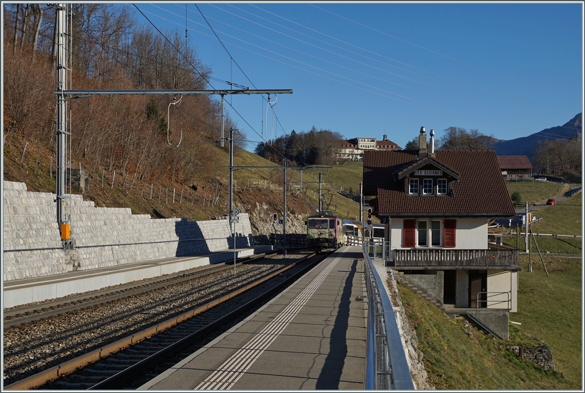 Die MOB GDe 4/4 6006  Aigle les Murailles  ist mit ihrem MOB GoldenPass Panoramic bestehend aus dem Bs 222, Bs 234, Bs 233 und BDs 224 (wobei letztere entgegen der Bezeichnung über 1.Klasse Sitze verfügt) auf dem Weg von Zweisimmen nach Montreux und dabei auf der Durchfahrt in Les Sciernes.

26. Nov. 2020