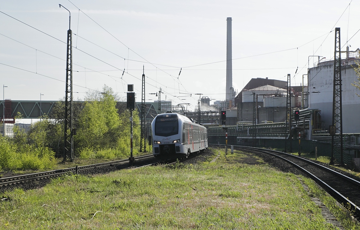 Die RB-Linie 35 von Mönchengladbach nach Gelsenkirchen wird von Abellio-Flirt 3 bedient, hier fährt am 23.04.2021 ET 25 2201 vor der Kulisse der Bayerwerke in Krefeld-Uerdingen in Hohenbudberg Chempark ein. Obwohl die Züge der RB komplett auf deutschem Gebiet verkehren, erfolgen die Stationsansagen auch in niederländisch (Abellio Deutschland ist ein Tochterunternehmen der Abellio Transport Holding B.V., die sich im Besitz der Nederlandse Spoorwegen).