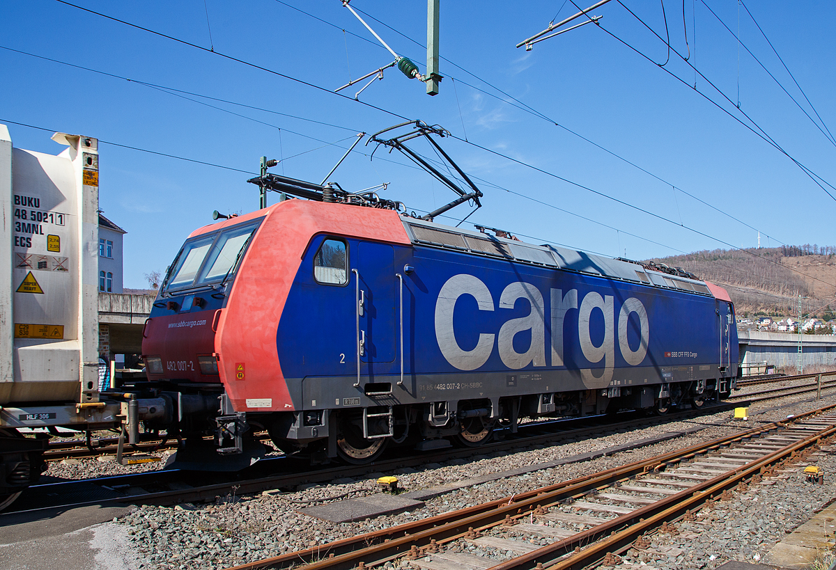 Die Re 482 007-2 (91 85 4482 007-2 CH-SBBC) der SBB Cargo AG zieht am 24.03.2021 einem HUPAC-KLV/Container-Zug durch Niederschelden in Richtung Siegen, hier hat sie gerade den Bü 343 (Km 112,183 der Siegstrecke KBS 460) passiert. 

Die TRAXX F140 AC1 wurde 2002 von Bombardier in Kassel unter der Fabriknummer 33474 gebaut und an die SBB Cargo AG geliefert. Sie hat die Zulassungen und Zugbeeinflussungssysteme für die Schweiz und Deutschland. Zurzeit ist sie an die SBB Cargo International AG vermietet.