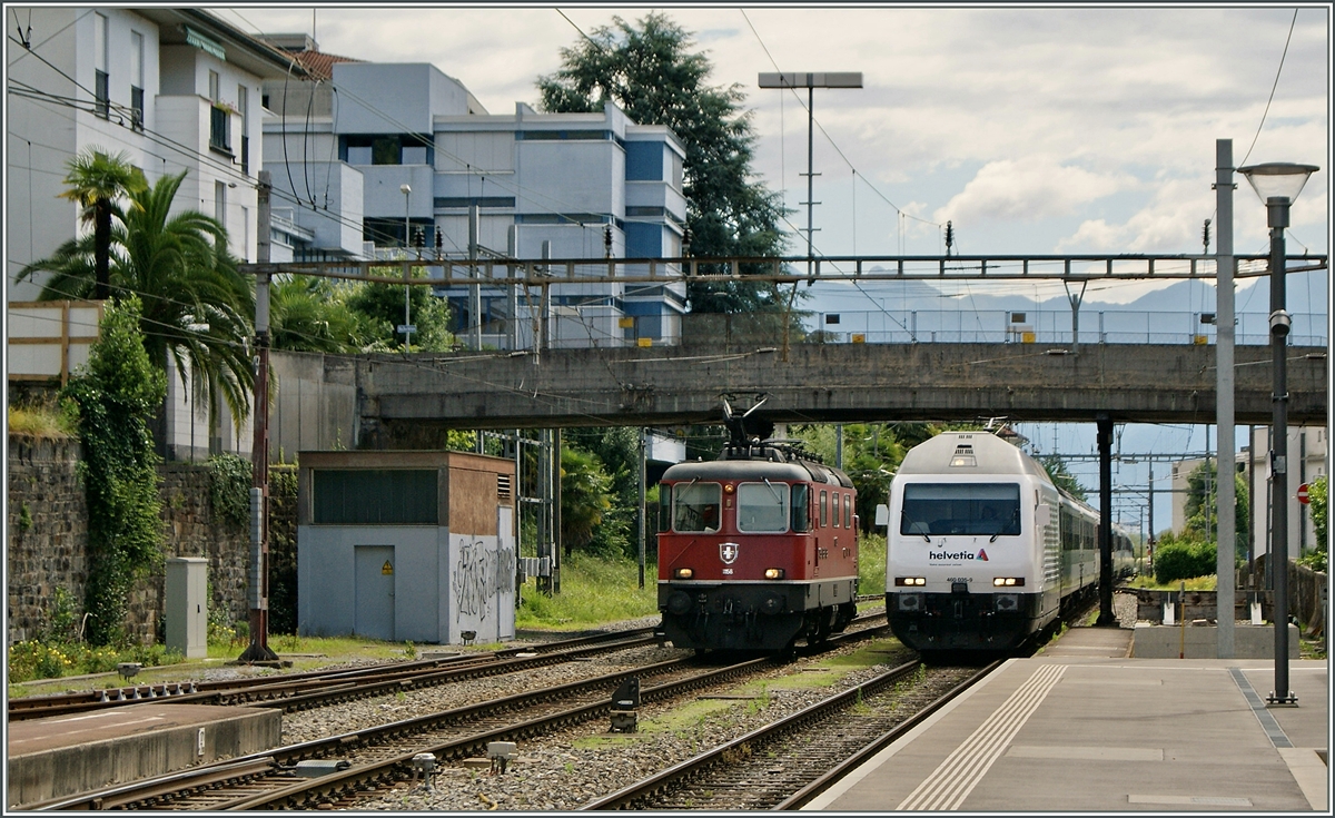 Die SBB Re 460 erreicht mit ihrem IR den Kopfbahnhof Locarno, eine Re 4/4 II, welche den Zug übernehmen wird steht schon bereit. 
21. Juni 2015