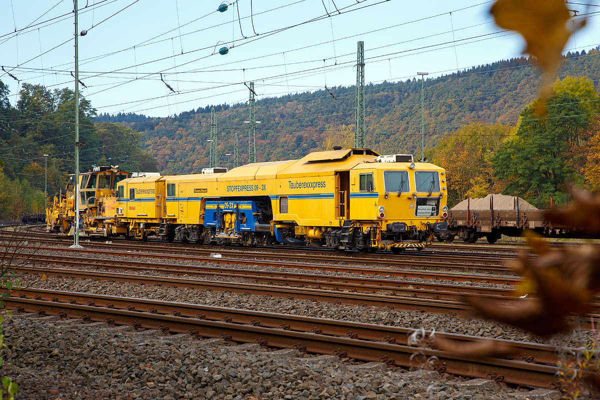 
Die STRABAG Tauberexxpress eine Plasser & Theurer Stopfexpress CSM 09 – 3X (PL) (Gleisstopfmaschine), Schweres Nebenfahrzeug Nr. 99 80 9121 004-2 D-BRS, der BMTI Rail Service GmbH (Servicebetrieb der STRABAG SE), abgestellt am 23.10.2016 in Betzdorf/Sieg.

Ausrüstung:
- Proportional-Parallel-Nivelliersystem
- Einsehnen: 3-Punkt-Richtsystem mit Lasersteuerung
- kombinierter Höhen-Richtlaser (KHR)
- automatischer Leitcomputer ALC mit zusätzlichen USB-Anschluss, WIN-Version, Disketten- und CD-Laufwerke
- Datenverarbeitung aller EM-SAT Daten möglich
- digitaler 8-Kanal-Schreiber, inkl. Rec-Funktion, DAR-Graph und DAR-Control (Software zum Bedienen und Anzeigen des MKS und dessen Daten)
- Mephisto Laser-Fixpunkt-Messgerät
- Vorkopfverdichter zum Verdichten der Bettungsschulter
- schallisolierte Bedienerkabine
- 2 x Dreischwellen-Stopfaggregate, Stopfleistung bis 2.200 m /h möglich
- Laserwagen zur Aufnahme des Lasersenders, selbst fahrend und mit integriertem Wegmessrad
- hochverschleißfeste Stopfpickel
- polnische Sicherheitsausrüstung für Eigenfahrt bei PKP

Technische Daten:
Hersteller:  Plasser & Theurer
Baujahr: 2001
VDM-Nr.: 99 80 9121 004-2 D-BRS

Motor: wassergekühlter Caterpillar E3412 E/DITA 12-Zylinder -Dieselmotor
Drehzahl: 2.100 U/min
Leistung: 704 kW
max. Geschwindigkeit in Eigenfahrt: 100 km/h
max. Geschwindigkeit in Schleppfahrt: 100 km/h
Eigenfahrtrichtung: beidseitig
Achsanzahl: 7
Sifa/PZB/ Zugbahnfunk (analog / digital): ja    
Arbeitsgeschwindigkeit: bis zu 2.200 m/h
Arbeitsweise:  drei. oder einschwellig
min. Radius bei Arbeit: 200 m
min. Radius bei Fahrt: 150 m

Fahrzeug: 
Zulassung: gemäß Richtlinien EBA/DB AG §32
Spurweite: 1.435  mm
Eigengewicht: 100,0  t
Höhe: 3.900  mm
Breite: 3.000  mm
Länge über Puffer:  29.900 mm

Dahinter steht die P&T Schnell-Schotterverteil- und Planiermaschine SSP 110 SW, Schweres Nebenfahrzeug Nr. 99 80 9425 014-4 D-STRA.
