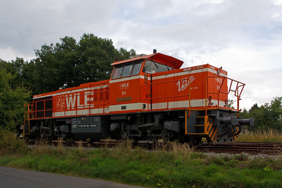 Die WLE 51  Kreis Warendorf  (Westflische Landes-Eisenbahn) eine MaK G 1206 steht am 17.09.2013 am einem Werksanschlu in Burbach-Holzhausen. Die Lok wurde 2002 bei Vossloh unter Fabriknummer 1001150 gebaut. Die komplette NVR-Nummer ist 92 80 1275 106-3 D-WLE, die EBA-Nummer EBA 02L22K 001.