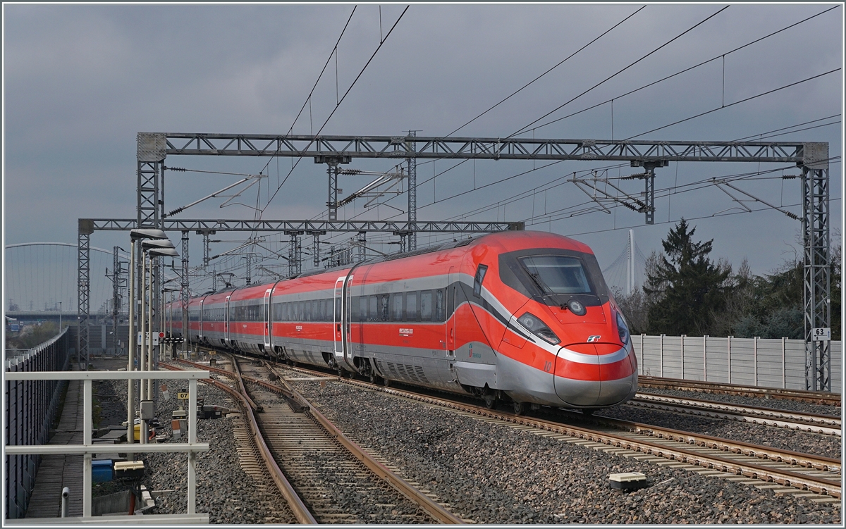 Durch den hier haltenden und etwas verspäteten ETR 500 037 etwas aus gebremst, ist der FS Trenitalia ETR 400 010 als Frecciarossa 1000 FR 9624 von Roma (ab 10:20) nach Milano (an 13:35 etwas weniger schnell unterwegs, als er durch den Bahnhof von Reggio Emilia AV fährt. 

14. März 2023