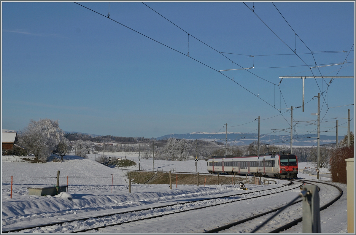 Eein SBB RBDe 560  Domino sind auf dem Weg nach Romont und verlässt gerade diedie Dienst- und Kreuzungsstation Vuisternens-devant- Romont. Weit im Hintergrund ist sogar noch der Jura zu erkennen. 

23. Dezember 2021