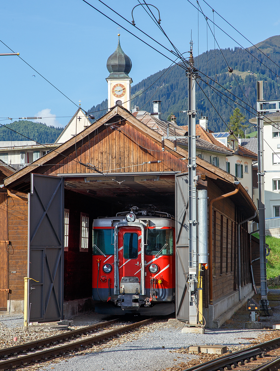 Ein Blick in die Remise der MGB beim Bahnhof Disentis/Mustér am 07.09.2021. Hier steht ein elektrischer Zahnrad-Gepäcktriebwagen MGB Deh 4/4 I, ex FO Deh 4/4 I, welche Fahrzeugnummer (51 bis 55) es ist kann in nicht sagen, da die Nummern an den Fronten nicht angeschrieben werden. Die zusehende Front, wäre im Betrieb, die dem Zug zugewandte Seite.

Diese Gepäcktriebwagen wurden 1972, für die damalige bis zur Fusion (zum 01. Jan. 2003) eigenständigen  Furka-Oberalp-Bahn (FO), gebaut. Der Triebwagenkasten ist von SIG, die Triebdrehgestelle von SLM und die elektrische Ausrüstung von BBC.
