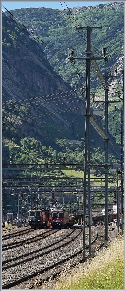 Ein etwas gewagter Schnitt mit Blick auf die nach Andermatt aufsteigende Schöllen-Schlucht und die im Bahnhof von Göschenen zu sehenden Re 4/4 II in Grün und Rot.
Während die beiden Roten Re 4/4 II mit einem Güterzug Richtung Erstfeld unterwegs sind, begleitet die grüne SBB Re 4/4 II 11161 den SF-Dampfzug über von Erstfeld nach Bellinzona (und zurück).
28. Juli 2016
