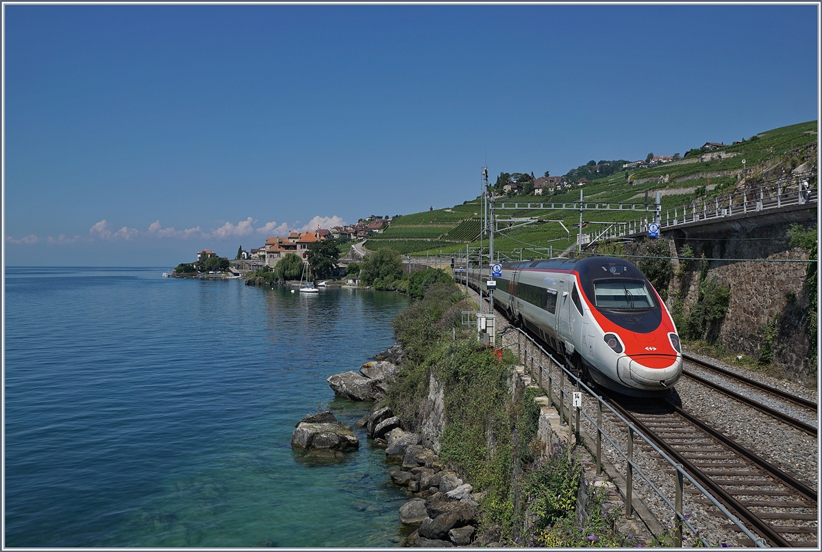 Ein SBB RABe 503 / ETR 610 als EC auf dem Weg nach Genève kurz nach St-Saphorin. Im Hintergrund ist bereits Rivaz zu sehen. 

19. Juli 2018