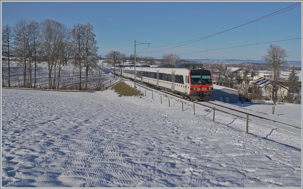 Ein tpf und ein SBB RBDe 560  Domino sind als RE 4016 von Düdingen nach Bulle unterwegs und erreichen in Kürze die Dienst- und Kreuzungsstation Vuisternens-devant- Romont. Weit im Hintergrund ist sogar noch der Jura zu erkennen. 

23. Dezember 2021