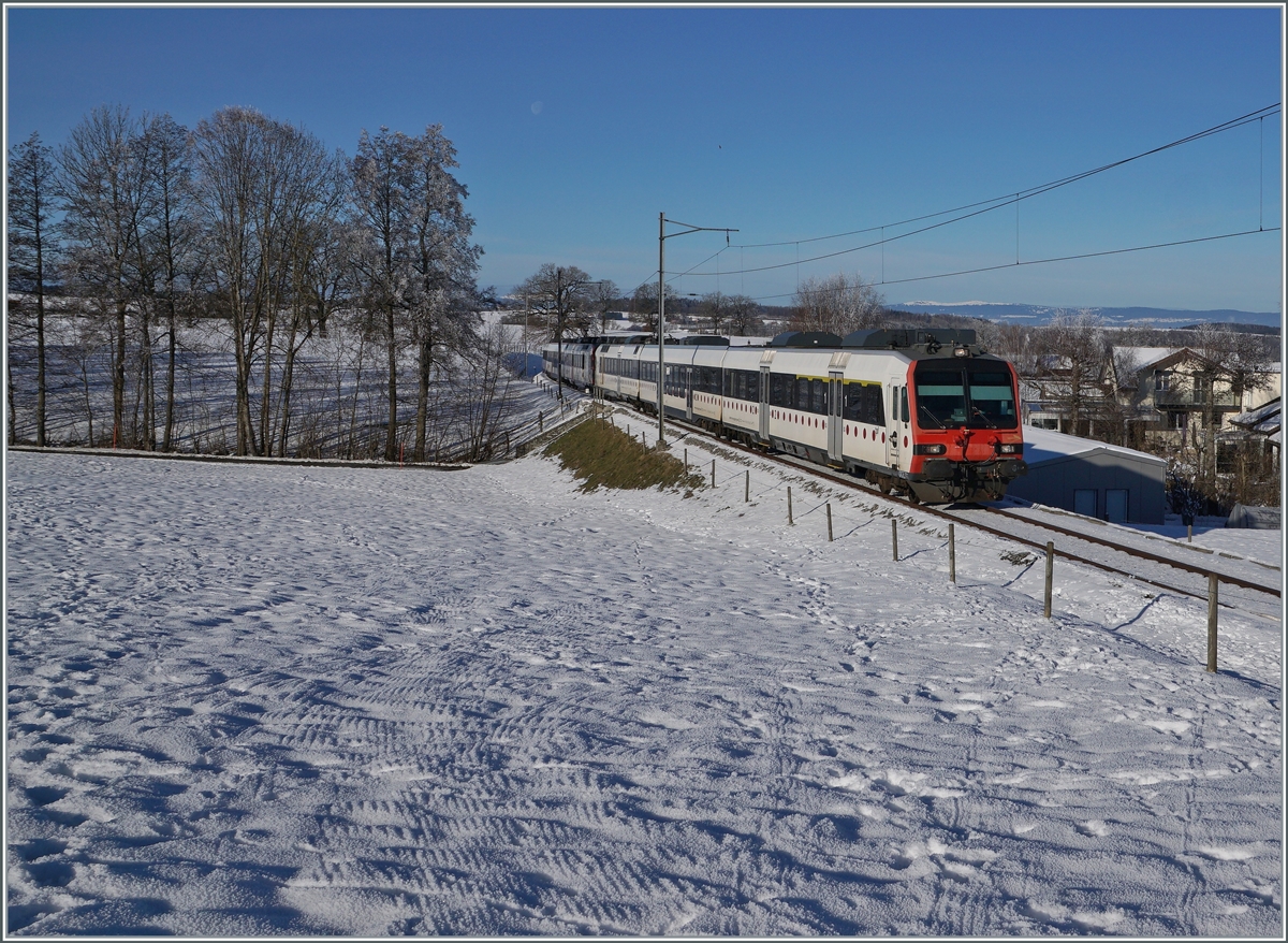 Ein tpf und ein SBB RBDe 560  Domino sind als RE 4016 von Düdingen nach Bulle unterwegs und erreichen in Kürze die Dienst- und Kreuzungsstation Vuisternens-devant- Romont. Weit im Hintergrund ist sogar noch der Jura zu erkennen.

23. Dezember 2021