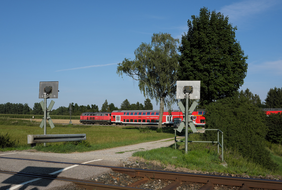 Eine 218 (aller Wahrscheinlichkeit nach 218 428-1) beschleunigte am frühen Abend des 07.08.17 ihren Doppelstockzug aus Markt Schwaben heraus in Richtung Mühldorf.
Im Vordergrund erkennt man das Gleis der KBS 999.2 (S-Bahn-Strecke Erding - Markt Schwaben).