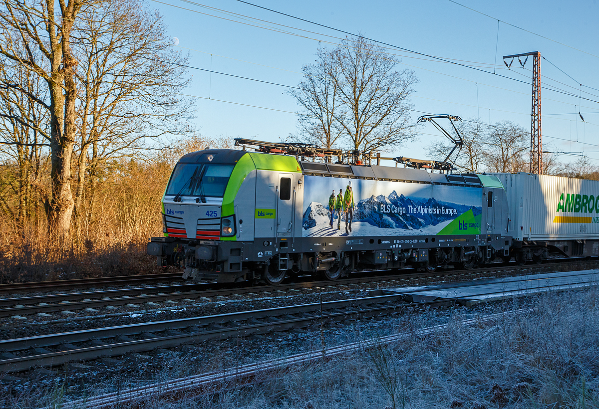 Eine der 25 neuen von der BLS Cargo in der 2. Serie bestellten Re 475 (Siemens Vectron MS)....
Die BLS Cargo 425  – Re 475 425-5 (91 85 4475 425-5 CH-BLSC) fährt am 11.01.2022 mit einem KLV-Zug durch Rudersdorf (Kr. Siegen) über die Dillstrecke (KBS 445) in nördlicher Richtung.

Die Siemens Vectron MS wurden 2020 von Siemens unter der Fabriknummer 22896 gebaut, sie hat die Zulassungen für CH/ D/ A/ I / NL/B und kann so vom Mittelmeer bis an die Nordsee ohne Lokwechsel durchfahren. Sie haben eine Höchstgeschwindigkeit von 200 km/h und eine Leistung von 6.400 kW.

Nach Abschluss der Lieferungen der 2. Serie hat die BLS Cargo dann insgesamt 40 Loks der Baureihe Re 475 (Siemens Vectron MS). Der kleine Unterschied zwischen der beiden Serien ist nur das die Lok der 2. Serie auch durch Belgien fahren darf.
