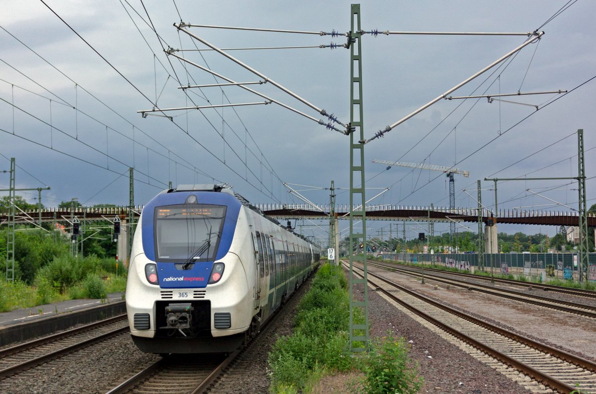 Eine Doppeltraktion 9442 von National Express mit 9442 365 am Schluss verlsst auf der Fahrt als RE7 nach Krefeld Opladen und fhrt fr einige hundert Meter an der Gterzugstrecke in Richtung Gremberg entlang.