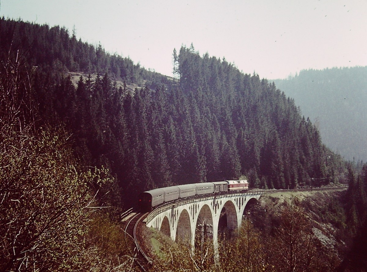 Eine DR 119er mit einem Personenzug am 10.05.1980 auf einer Br�cke bei Lauscha. (Foto: Klaus Pollm�cher)