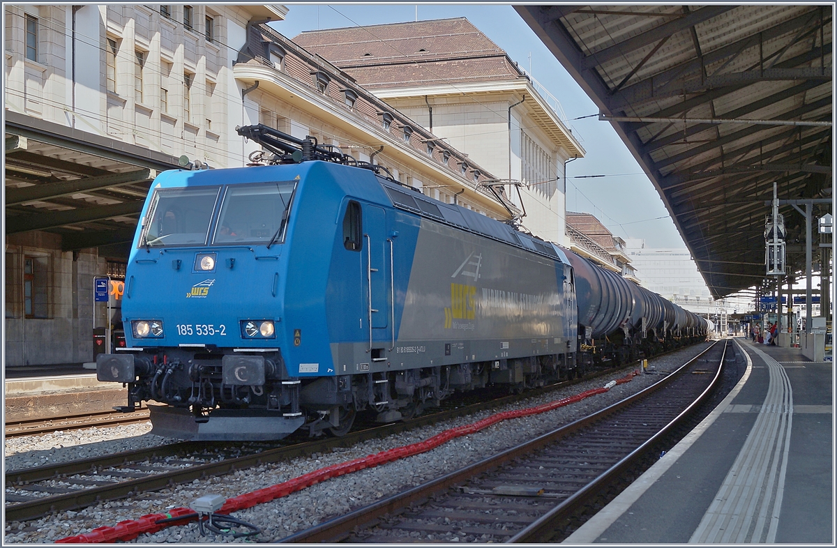 Eine Lok der BR 185 ist seit etlichen Jahren eigentlich etwas alltägliches: In Lausanne hingegen bekommt man seit dem Ende der RTS diese Lokgattung eher selten zu sehen, so dass es sich selbst bei ungünstigem Licht anbot, die für die WRS fahrende 182 535 (UIC 91 80 6185 535-2 D-ATLU) zu fotografieren, die mit einem Kesselwagenblockzug auf Gleis 2 auf die Weiterfahrt wartet. 

27. Juni 2020