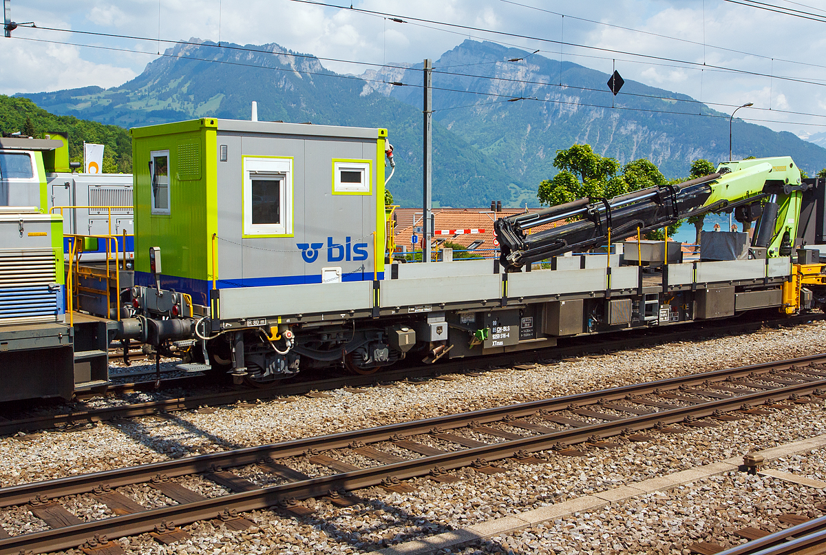 Erhaltungsfahrzeug EHF bzw. der selbstfahrende Dienstwagen XTmas 516 mit Palfinger Kran 100002 D 100mt  (99 85 92 59 516-4 CH-BLS) abgestellt am 28.05.2012 beim Bahnhof Spiez (aufgenommen aus einfahrendem Zug).

Für die Durchführung der Arbeiten innerhalb der Erhaltungsabschnitte werden Erhaltungsfahrzeuge (EHF)  mit modularen, den jeweiligen Anforderungen entsprechenden, Aufbauten und Ausrüstungen eingesetzt.
Im Laufe des Jahres 2006 erhielt die BLS insgesamt 13 Erhaltungsfahrzeuge von der Firma SCHÖRLING-BROCK GmbH in Gehrden bei Hannover. Von den13 Fahrzeugen besitzen 9 einen hydrostatischen Antrieb, der den Eigenbetrieb bis zu einer Geschwindigkeit von 60 km/h erlaubt, der geschleppte Betrieb ist bis 100 km/h zugelassen. Die UIC-Konformität der Konstruktion ist gegeben. Die Fahrzeuge sind im Konzept eines 60“-Containerwagens gestaltet mit unterschiedlichen Aufbauten und einem Leergewicht zwischen 21 t für einen nicht angetriebenen und 47 t für diesen angetriebenen Tragwagen mit aufgebautem 100mt-Kran und 14 Tonnen Gegengewicht. Bei dem einheitlichen Gesamtgewicht aller Wagen von 72 t ergeben sich somit für Baufahrzeuge beachtliche Zuladungskapazitäten.

Die geringe Ladehöhe von 1.140 mm sowie die maximale Pufferhöhe von 990 mm ergeben mit der damit einhergehenden Überlademöglichkeit für Langgut vielseitige Anwendungsmöglichkeiten.
Die Bremsanlage wird generell mit einer Federspeicherbremse ergänzt. Bei den angetriebenen Fahrzeugen ist neben der Lokbremse auch noch eine Anhängerbremse vorhanden.

Technische Daten Grundfahrzeug mit Antrieb:
Angetrieben werden jeweils die inneren Achsen der Drehgestelle mittels Hydrostat und Getriebe von einem 210 kW starken Deutz-Motor mit Partikelfilter der Fa. Hug Engeneering AG.
Der Energiebedarf der Aufbauten oder von Werkzeugen neben dem Fahrzeug wird von einem hydrostatisch angesteuerten Generator mit 50 bzw. 60 kVA gewährleistet. Um eine möglichst tief liegende Ladefläche verwirklichen zu können, kommen vom UIC-Standarddrehgestell Y31 abgeleitete Drehgestelle der Bauart Y31Lssif-D-(AK) von der Firma Eisenbahn Laufwerke Halle (ELH) zum Einsatz, welche sich bei einem Neuraddurchmesser von 760mm durch eine tief liegende Abstützebene für das Untergestell auszeichnen
Für Start, Beleuchtung und Gewährleistung von Notfunktionen über eine EPumpe stehen 24 V/630 Ah Batteriekapazität zur Verfügung.
Als Steuerungselektronik kommen fahrzeugtaugliche Digsy Outdoor-Komponenten der Firma Intercontrol mit einer Funkfernsteuerung der Firma Theimeg zum Einsatz. Diese Kombination ist bereits auf Baudienstfahrzeugen der Deutschen Bahn AG im Einsatz.
Neben den Kranaufbauten werden variabel aufsetzbare Aufbauten wie Kabelrollböcke, Arbeitsbühnen sowie Mannschafts- und Magazincontainer mit 10 Fuß und 20 Fuß Länge eingesetzt.
Fixe und abnehmbare Aufbauten sind als Mannschaftsraum und WC ausgebildet.
Zum Einsatz der Funkfernbedienung mit V-Max 80 km/h sind diese mit Notbremsventil ausgeführt. Die Steuerung der Erhaltungsfahrzeuge erfolgt im Fahrbetrieb generell mit einer Theimeg-Funkfernsteuerung. Im Kranbetrieb erfolgt die Versetzfahrt mit bis zu 9,5 km/h über die Kranfernbedienung. Als Rückfallebene dient eine Kabelfernbedienung (bis 40 km/h).

Bei der BLS werden folgende Ausbildungen von angetriebenen Erhaltungsfahrzeugen (EHF) eingesetzt:
3 Fahrzeuge für Mannschaft, Material und Werkzeug mit ca. 8,0 m freier Ladeflächenlänge, asymmetrisch aufgebautem Kran (ca. 14 mt) für die Manipulation von Paletten und leichten Gütern sowie die Unterstützung von Arbeitsprozessen.
5 Fahrzeuge mit Kran (20 mt) bzw. dreiteiliger Arbeitsbühne und Fahrleitungsdrückanlage. 2 Kräne sind auch mit Arbeitskorb für die Fahrleitungsmontage ausgerüstet.
1 Fahrzeug (dieses hier) mit großem Kran (ca.100 mt) mit dem für die Störungsintervention zusammen mit einem anderen Fahrzeug auch die Zungenvorrichtungen der Schnellfahrweichen mit bis zu 64 m Länge und Herzstücke mit bis zu 7,5 t Gewicht und 22,5 m Länge transportiert und manipuliert werden können
Fünf weitere von der BLS AG selbstgebaute Fahrzeuge kamen 2012 und 2013 (XTmas 521-525)  hinzu. 2x mit Kran PKR 200 C (20 mt), 1x mit PKR 480 D (48 mt) und 2x mit Kran PK 29002 C (29 mt). Diese Fahrzeuge haben ein Deutz-Dieselmotor vom Typ TCD 7.8 L6 mit 230 kW Leistung.

TECHNISCHE DATEN:
Spurweite: 1.435 mm (Normalspur)
Achsfolge: (1Ao)  (Ao1)
Wagenlänge über Puffer: 19.640 mm
Drehzapfenabstand: 14.200 mm
Achsstand im Drehgestell: 1.800 m
Bruttogewicht aller dargestellten Fahrzeuge:  72 t
Eigengewicht  (XTmas 516): 54.5 t
Ladegewicht  (XTmas 516):  17.5 t
Ladelänge:  18.300 mm
Ladebreite:  2.760 mm
Ladehöhe:  1.150 mm
Pufferhöhe über SOK (Neuzustand ohne Beladung): 990 mm
Drehgestelle: Y31Lssif-D-(AK)
Raddurchmesser neu / abgenutzt:  760 / 700 mm
Motorleistung: 210 kW
Dieselmotor Typ:  Deutz BF 6M 1013 FC EURO III
Partikelfilter: mobiclean S / Hug Engeneering AG
Antriebsart: hydrostatisch, jeweils auf die innenliegende Achse der Drehgestelle
Bremsanlage: direkte Druckluftbremse,indirekte Druckluftbremse DK-GP-A, Hydrostatische verschleiß freie Bremse, Feststellbremse als Federspeicher (separat ansteuerbar).
Feststellbremse Federspeicher:  bis 40 ‰
Maximale Geschwindigkeit Eigenantrieb:  60 km/h
Maximale Geschwindigkeit geschleppt: 100 km/h
Maximale Geschwindigkeit Kranbetrieb:  9,5 km/h
