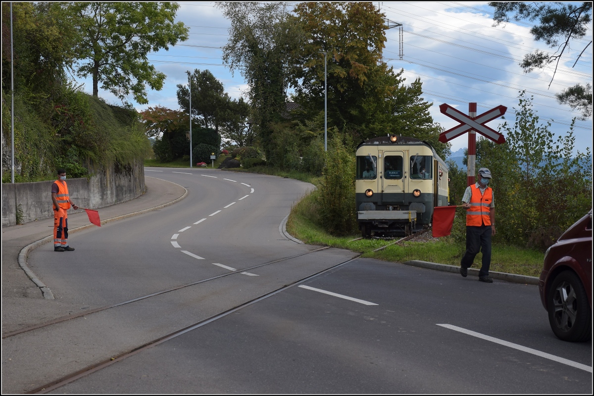 Fahrtag Wolfhuuser Bahn.

Passage des Bahnübergangs am Ortsende Wolfhausen, vorne der ABt der IG Stammgleis Wolfhausen–Bubikon. Oktober 2021.