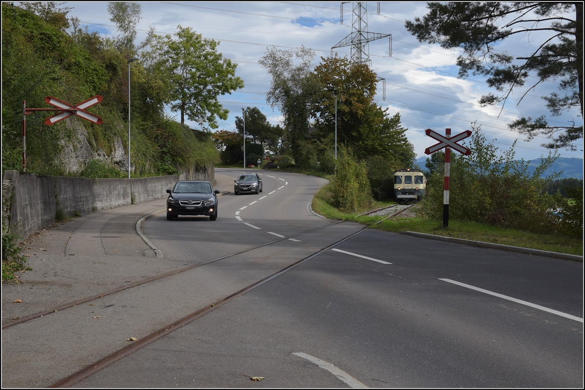 Fahrtag Wolfhuuser Bahn.

Passage des Bahnübergangs am Ortsende Wolfhausen, vorne der ABt der IG Stammgleis Wolfhausen–Bubikon. Oktober 2021.