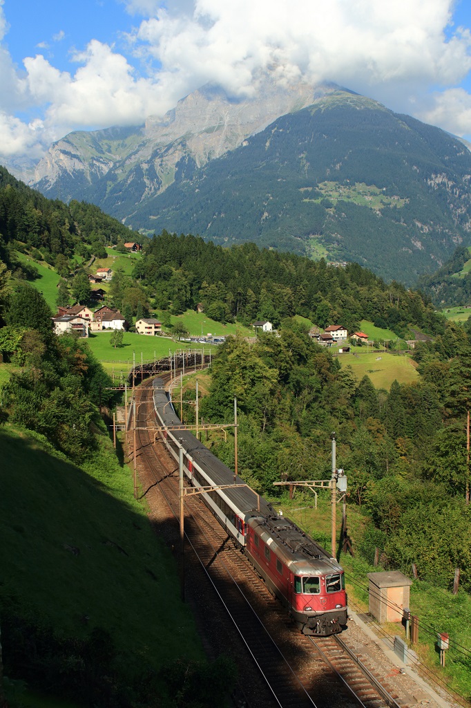 Fast der gleichen Stelle wie die Re 6/6 auf dem vorherigen Bild, allerdings etwas mehr als 33 Jahre später, nämlich am 11.09.2016, fährt eine Re 4/4 II mit dem IR 2327 von Basel SBB nach Locarno bei Intschi Richtung Gotthardtunnel. Gut, dass der IR pünktlich war, denn um 16.35 Uhr sind die Schatten schon bedrohlich nahe... 