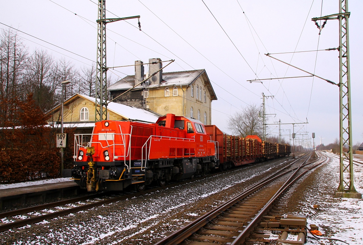Ganz langsam nähert sich 261 104-4 mit dem EK 53369(Flensburg-Neumünster)dem roten Signal am Bü Jübek und passiert dabei das alte Bahnhofsgebäude(inzwischen in Privatbesitz). Jübek 25.01.2014