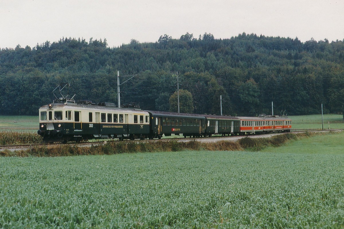 GFM/TPF: SBB Personenwagen auf Privatbahnen. Der alljhrlich im Monat Oktober stattfindende Murtenlauf fhrt noch immer zu einem aussergehnlichen Grosskampftag. Im Jahre 1971 pendelte an diesem bsonderen Anlass ein spezieller Pendelzug bestehend aus zwei ABDe 4/4 an beiden Enden sowie dem alten GFM-Mitteleinstiegwagen und zwei Verstrkungswagen der SBB zwischen Fribourg und damals noch Ins hin und her. Die Aufnahme ist zwischen Courtepin und Pensier entstanden.
Foto: Walter Ruetsch 